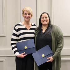 Two female recipients of the ABC program pose together with certificates